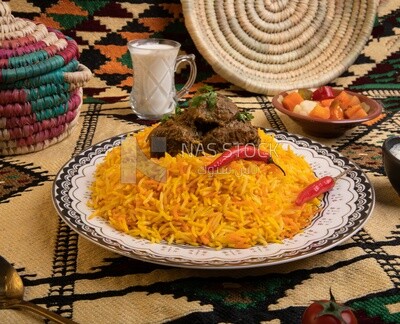 Wooden plate of delicious biryani rice with meat and a plate of dates,  traditional Arabic dishes, Arabic food, popular dishes, delicious recipes and dishes, delicious food