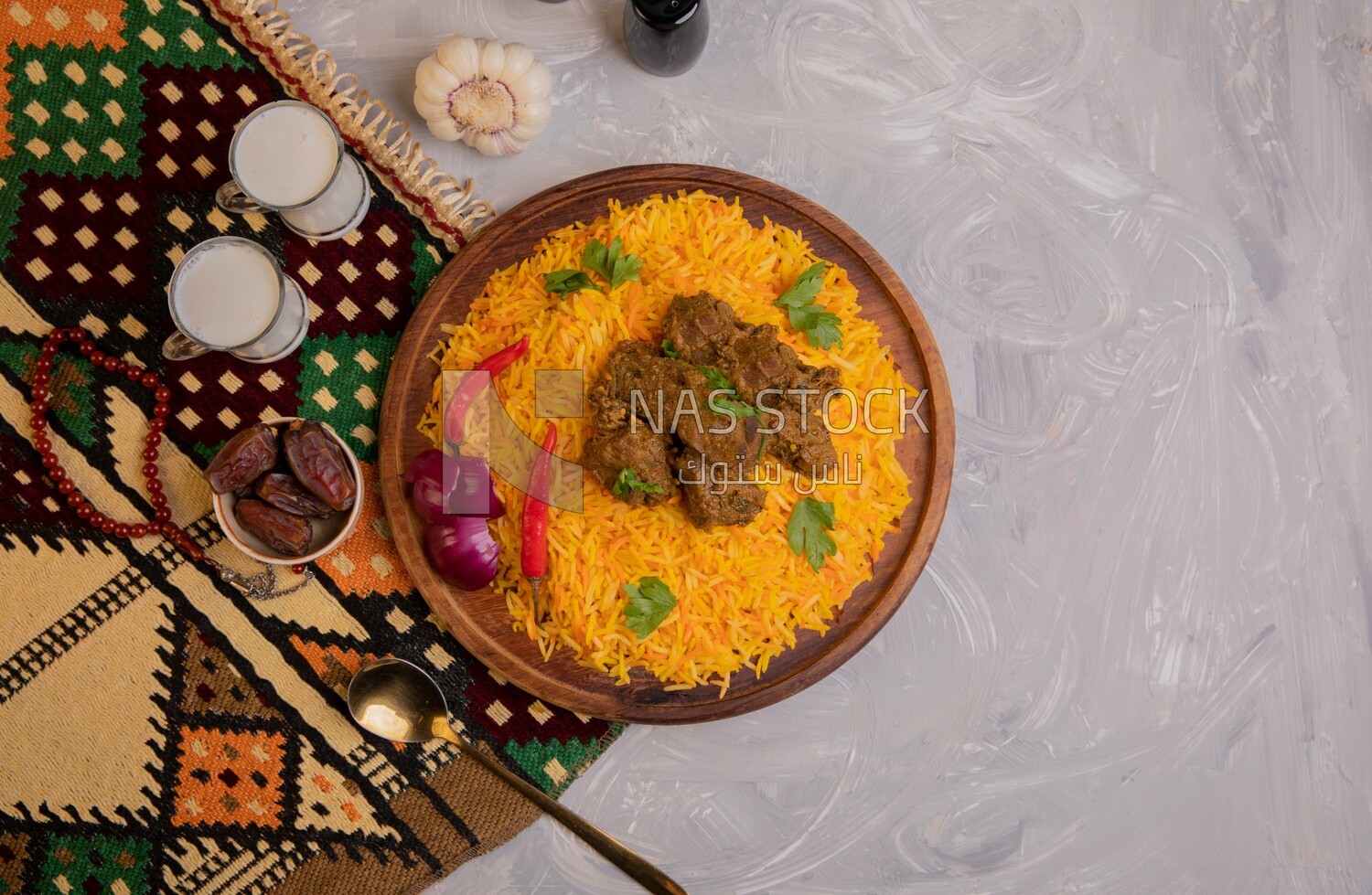 Wooden plate of delicious biryani rice with meat and two cups of milk and a plate of dates, traditional Arabic dishes, Arabic food, popular dishes, delicious recipes and dishes, delicious food
