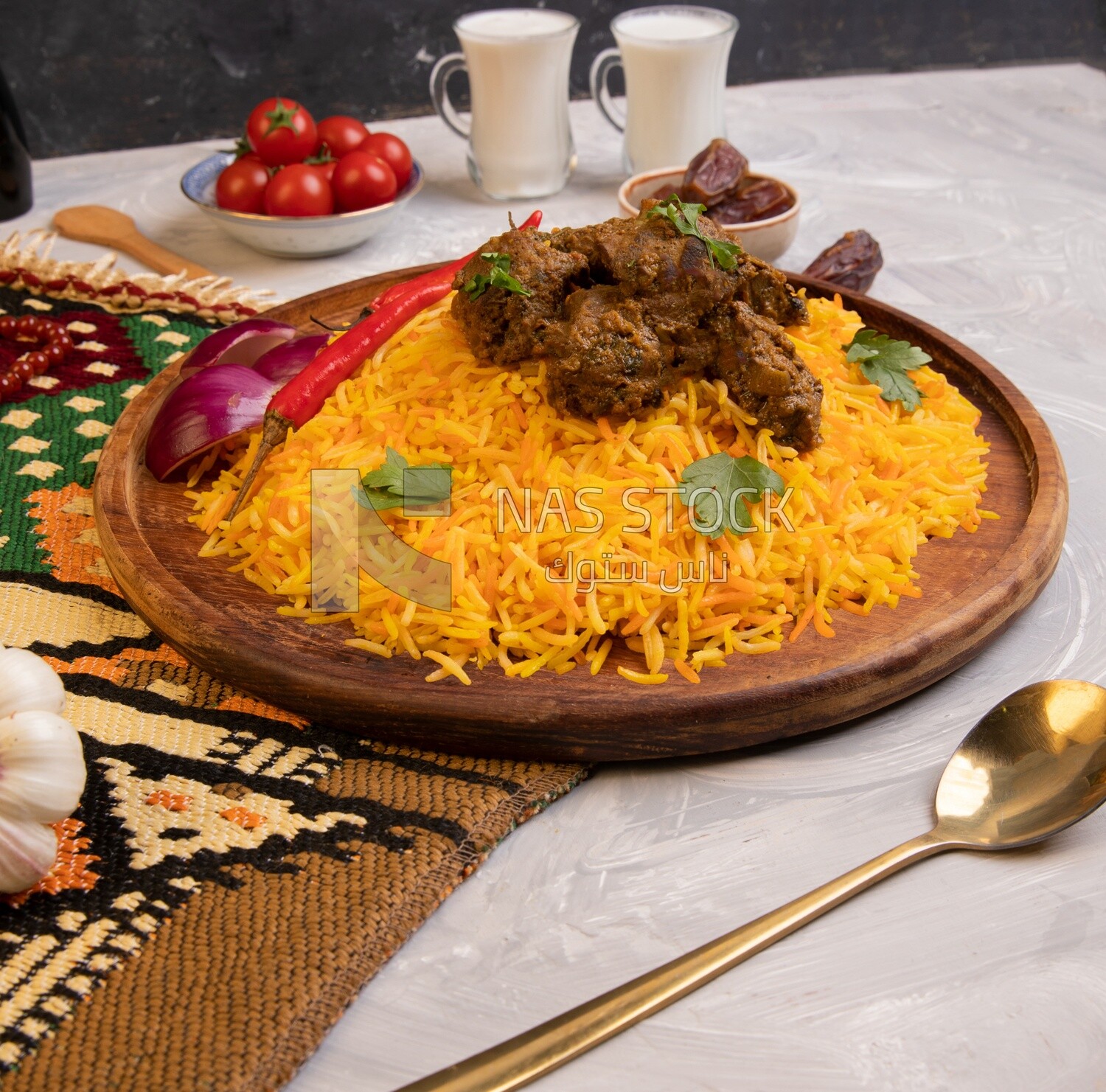 Wooden plate of delicious biryani rice with meat and two cups of milk and a plate of dates, traditional Arabic dishes, Arabic food, popular dishes, delicious recipes and dishes, delicious food