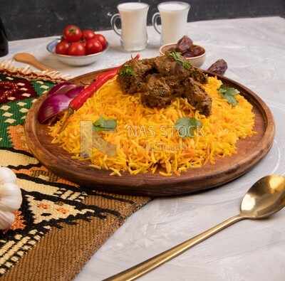 Wooden plate of delicious biryani rice with meat and two cups of milk and a plate of dates, traditional Arabic dishes, Arabic food, popular dishes, delicious recipes and dishes, delicious food