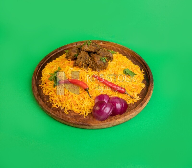 Wooden plate of delicious biryani rice with meat, traditional Arabic