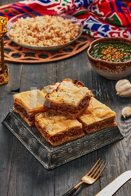 Plate of Molokhia, white rice, and crispy Phyllo Meat Pie (Egyptian goulash), traditional Arabic dishes, Arabic food, popular dishes, delicious recipes and dishes, delicious food