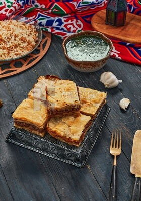 Plate of Molokhia, white rice, and crispy Phyllo Meat Pie (Egyptian goulash), traditional Arabic dishes, Arabic food, popular dishes, delicious recipes and dishes, delicious food