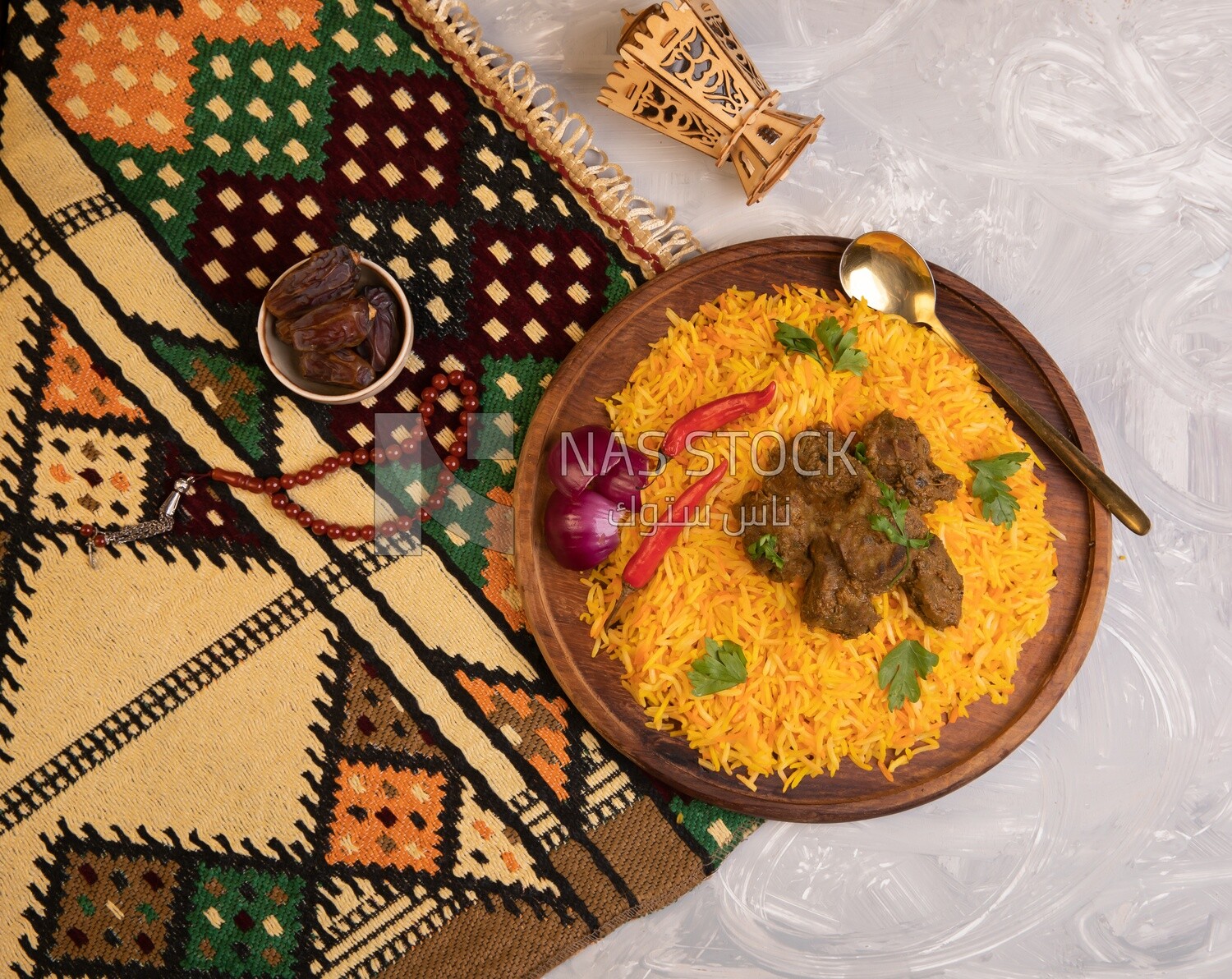 Wooden plate of delicious biryani rice with meat and a plate of dates,  traditional Arabic dishes, Arabic food, popular dishes, delicious recipes and dishes, delicious food