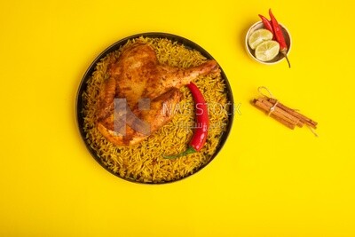 Plate of kabsa rice with chicken and cinnamon sticks, traditional Saudi food, Saudi restaurant, Saudi dishes