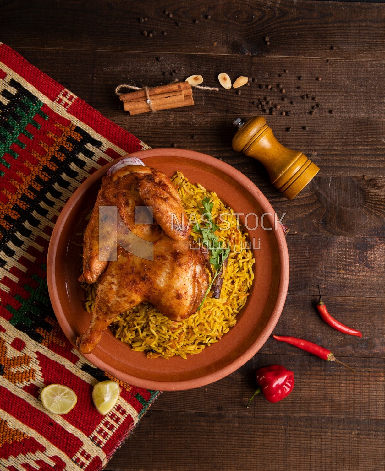 Plate of kabsa rice with chicken and cinnamon sticks, traditional Saudi food, Saudi restaurant, Saudi dishes