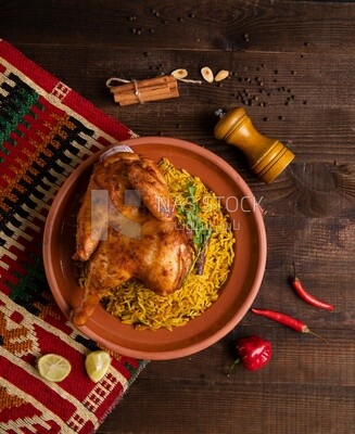 Plate of kabsa rice with chicken and cinnamon sticks, traditional Saudi food, Saudi restaurant, Saudi dishes