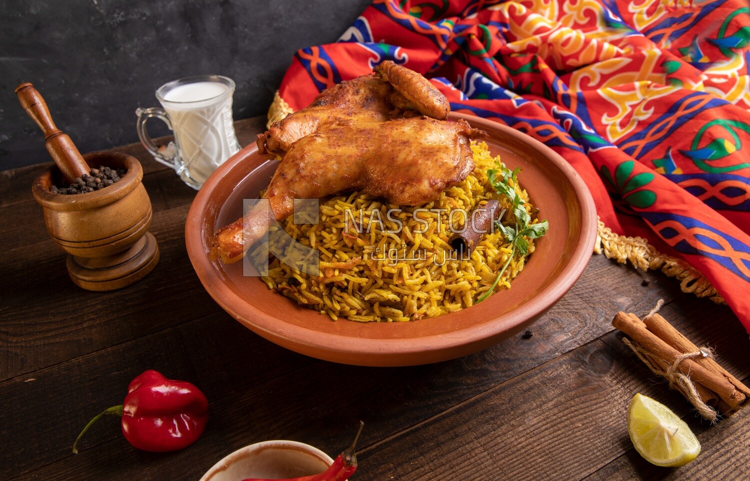 Plate of kabsa rice with chicken, cinnamon sticks, and a cup of milk, traditional Saudi food, Saudi restaurant, Saudi dishes