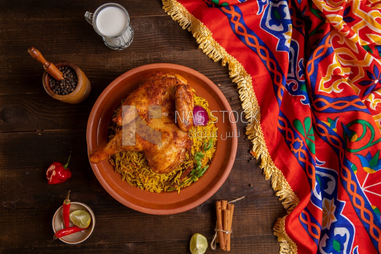 Plate of kabsa rice with chicken, cinnamon sticks, and a cup of milk, traditional Saudi food, Saudi restaurant, Saudi dishes