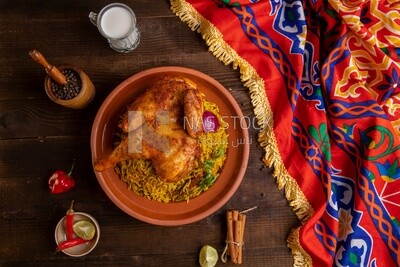 Plate of kabsa rice with chicken, cinnamon sticks, and a cup of milk, traditional Saudi food, Saudi restaurant, Saudi dishes