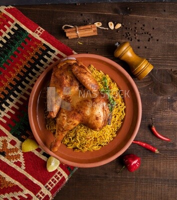 Plate of kabsa rice with chicken and cinnamon sticks, traditional Saudi food, Saudi restaurant, Saudi dishes