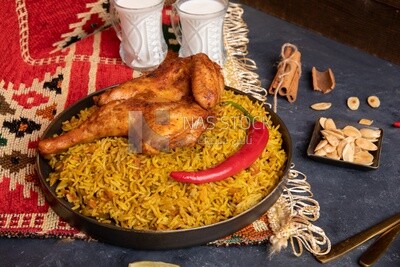 Plate of kabsa rice with chicken, cinnamon sticks, and two cups of milk, traditional Saudi food, Saudi restaurant, Saudi dishes