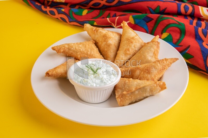 Plate of samosa with yogurt salad, popular dishes, appetizers, Arabic dishes, oriental dishes, restaurants for oriental Arabic food, delicious meals