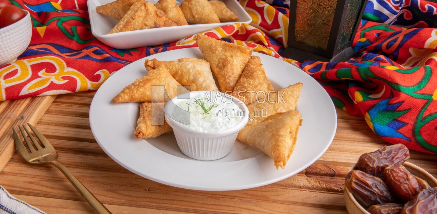 Plate of samosa with yogurt salad, popular dishes, appetizers, Arabic dishes, oriental dishes, restaurants for oriental Arabic food, delicious meals