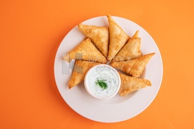 Plate of samosa with yogurt salad, popular dishes, appetizers, Arabic dishes, oriental dishes, restaurants for oriental Arabic food, delicious meals