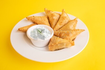 Plate of samosa with yogurt salad, popular dishes, appetizers, Arabic dishes, oriental dishes, restaurants for oriental Arabic food, delicious meals