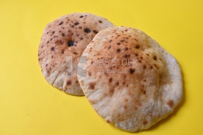 Arabic white bread, freshly baked, placed on a yellow background