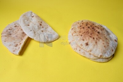 Arabic white bread, freshly baked, placed on a yellow background