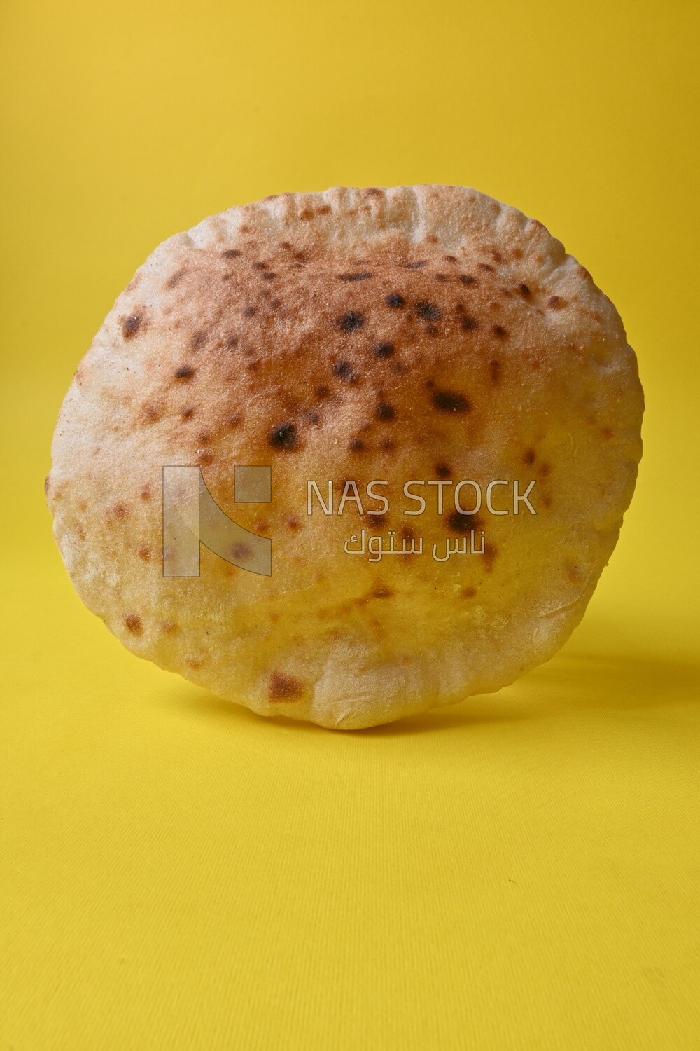 Arabic white bread, freshly baked, placed on a yellow background