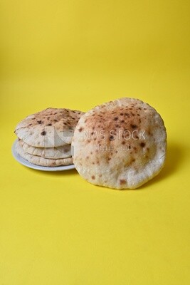 Arabic white bread, freshly baked, placed on a yellow background