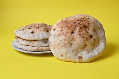 Arabic white bread, freshly baked, placed on a yellow background