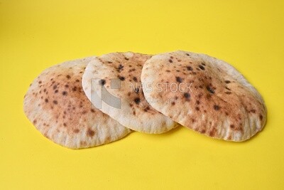 Arabic white bread, freshly baked, placed on a yellow background