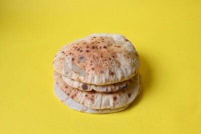 Arabic white bread, freshly baked, placed on a yellow background