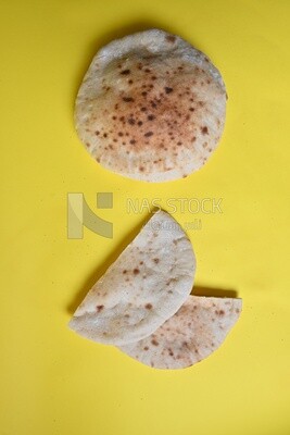 Arabic white bread, freshly baked, placed on a yellow background