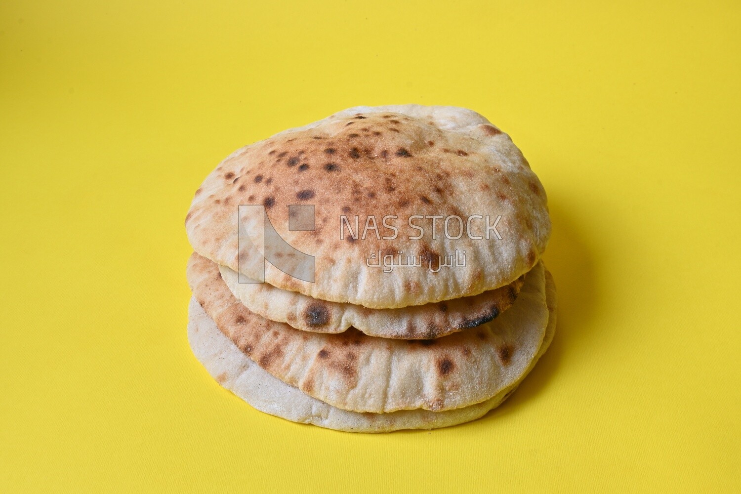 Arabic white bread, freshly baked, placed on a yellow background