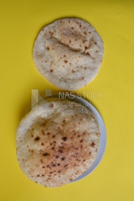 Arabic white bread, freshly baked, placed on a yellow background