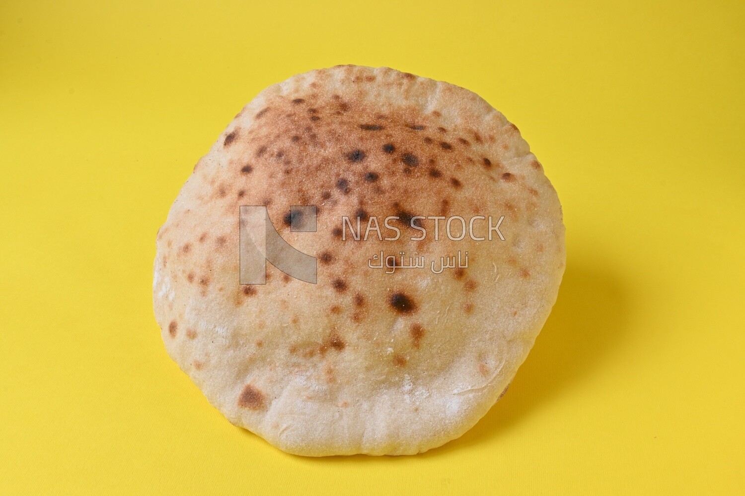 Arabic white bread, freshly baked, placed on a yellow background