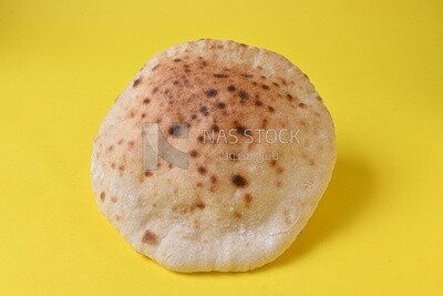 Arabic white bread, freshly baked, placed on a yellow background
