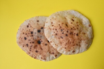 Arabic white bread, freshly baked, placed on a yellow background