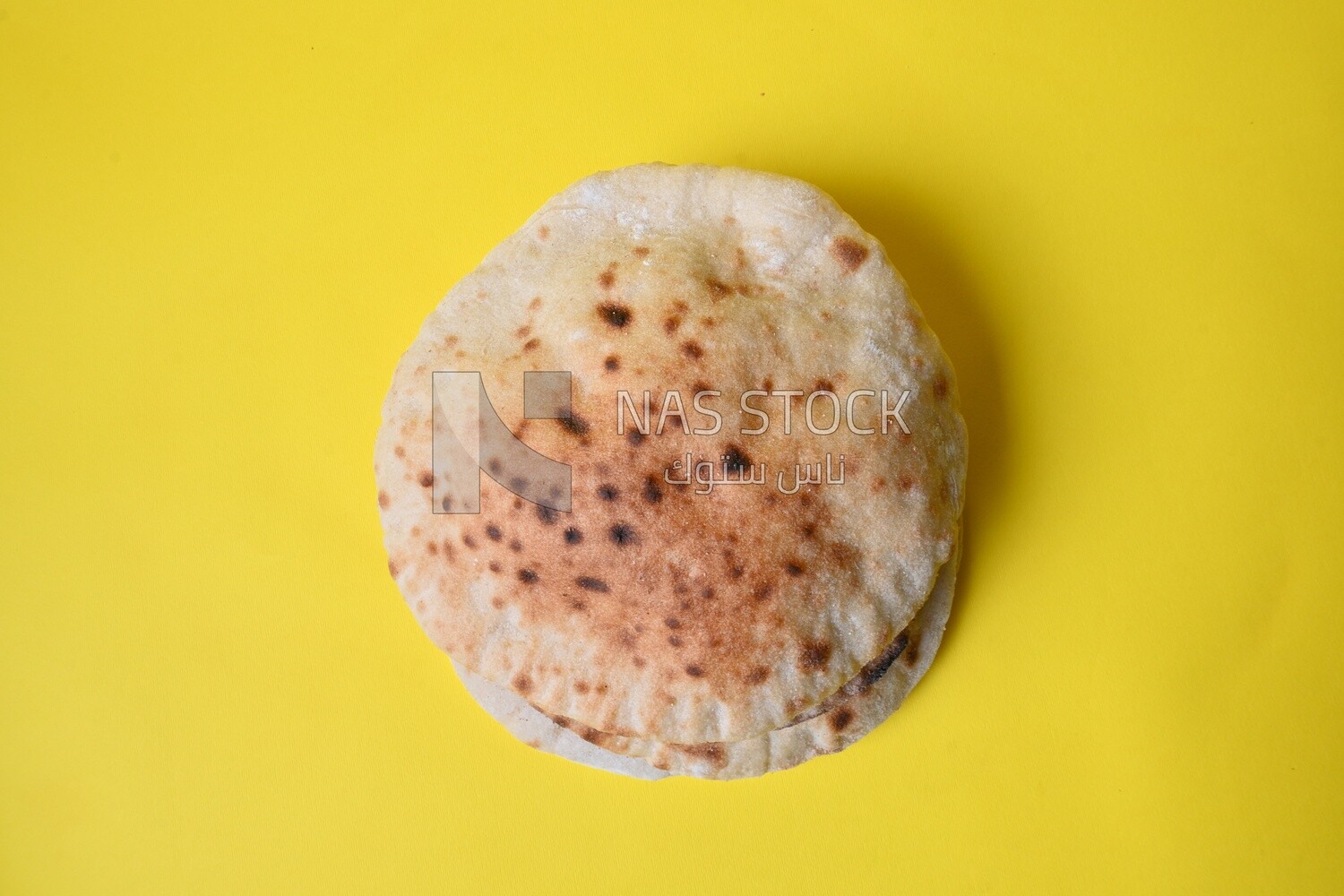 Arabic white bread, freshly baked, placed on a yellow background