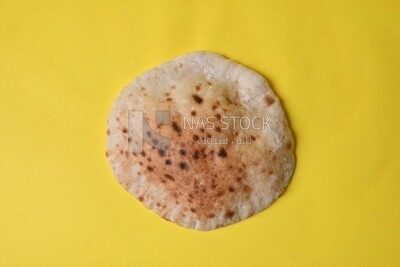 Arabic white bread, freshly baked, placed on a yellow background