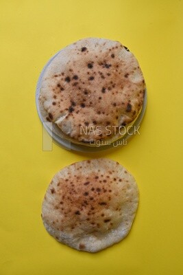 Arabic white bread, freshly baked, placed on a yellow background