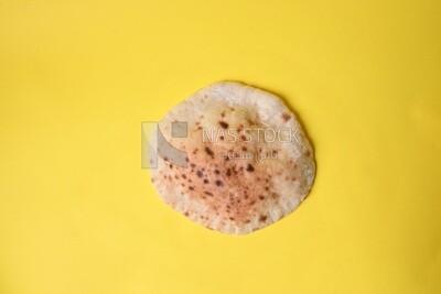 Arabic white bread, freshly baked, placed on a yellow background