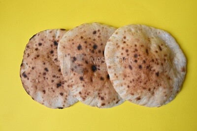 Arabic white bread, freshly baked, placed on a yellow background