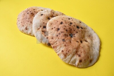 Arabic white bread, freshly baked, placed on a yellow background