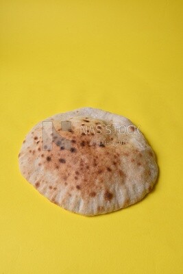 Arabic white bread, freshly baked, placed on a yellow background