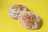 Arabic white bread, freshly baked, placed on a yellow background