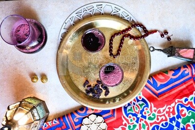 Jug of hibiscus beside a cup of hibiscus with ice, Ramadan juice, delicious juice