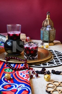 ابريق من الكركدية بجانب كوب به كركديه مع ثلج ، عصير رمضان ، عصير لذيذ