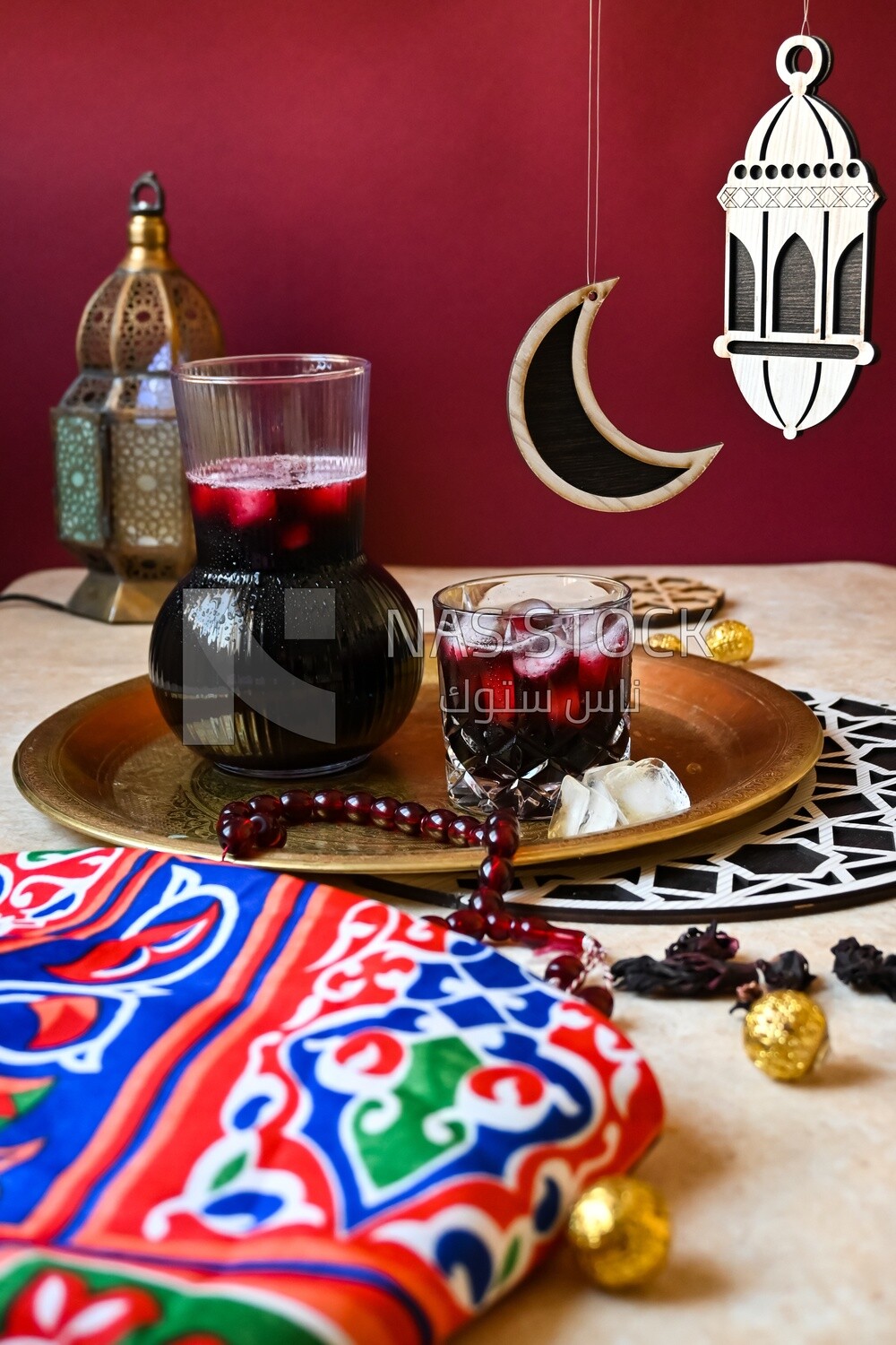 Jug of hibiscus beside a cup of hibiscus with ice, Ramadan juice, delicious juice