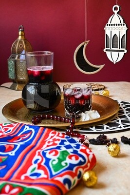 Jug of hibiscus beside a cup of hibiscus with ice, Ramadan juice, delicious juice