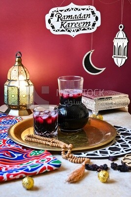 Jug of hibiscus beside a cup of hibiscus with ice, Ramadan juice, delicious juice