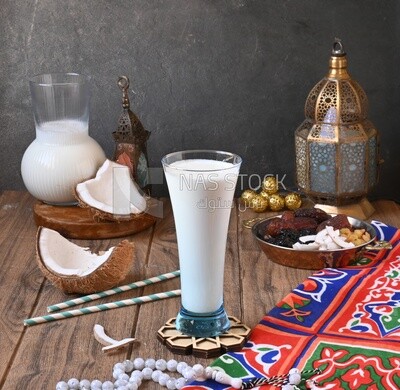Cup of sobia beside a coconut with a plate of dried fruits(khoshaf), delicious dessert, Ramadan juice, delicious juice, traditional juice