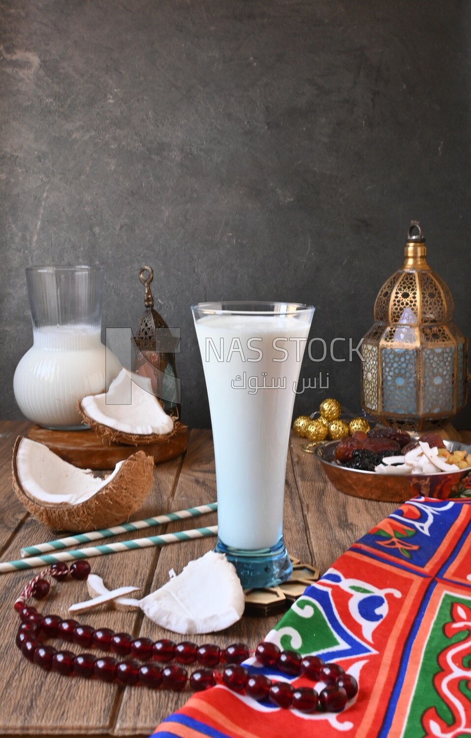 Cup of sobia beside a coconut with a plate of dried fruits(khoshaf), delicious dessert, Ramadan juice, delicious juice, traditional juice