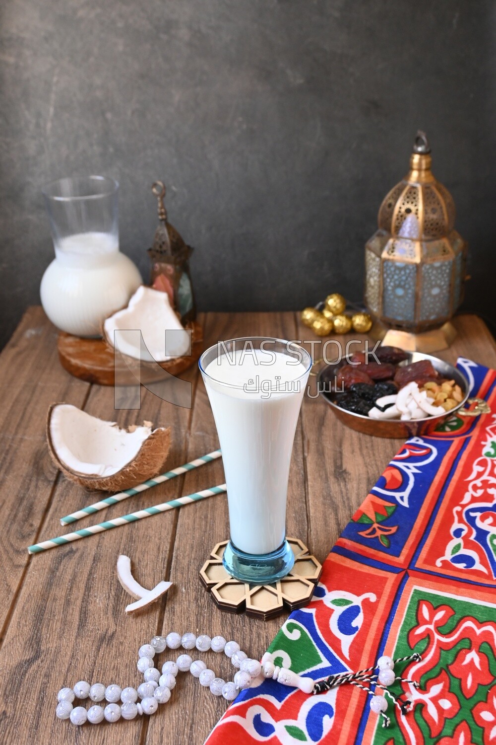 Cup of sobia beside a coconut with a plate of dried fruits(khoshaf), delicious dessert, Ramadan juice, delicious juice, traditional juice