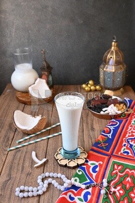 Cup of sobia beside a coconut with a plate of dried fruits(khoshaf), delicious dessert, Ramadan juice, delicious juice, traditional juice
